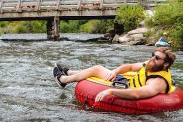 a person riding on a river tube in a body of water