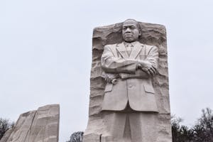 a large stone statue of a person with Martin Luther King Jr. Memorial in the background