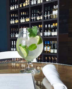 A mojito cocktail sits on a table in wine cellar