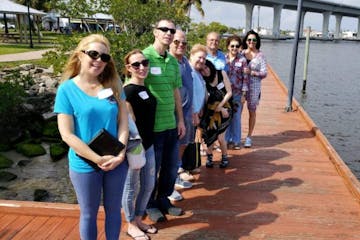 a group of people standing on a dock near the water