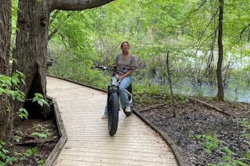 a person riding a bike down a dirt path in a forest