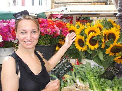 a woman is smiling while holding a flower