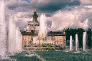 a fountain in front of a cloudy sky