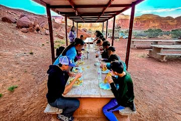 a group of people eating dinner at a picnic table
