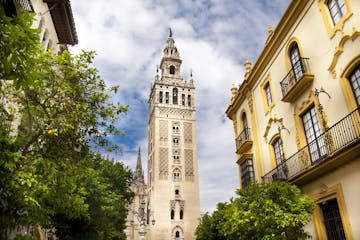 a large tall tower with a clock on the side of Giralda