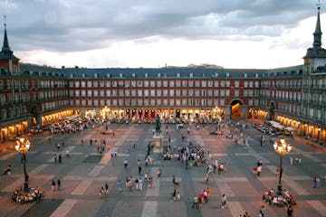 a group of people in a large city with Plaza Mayor, Madrid in the background