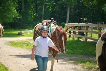 a girl leading a horse