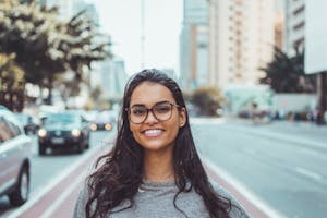 a girl wearing glasses and smiling at the camera