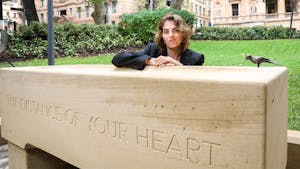 Tracey Emin sitting on a bench in front of a box
