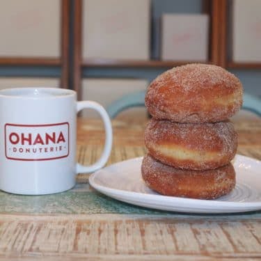 a doughnut sitting next to a cup of coffee