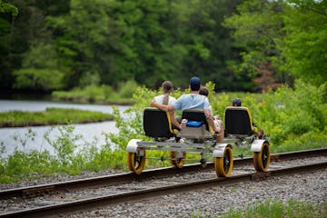 a person riding on the back of a train going down the river