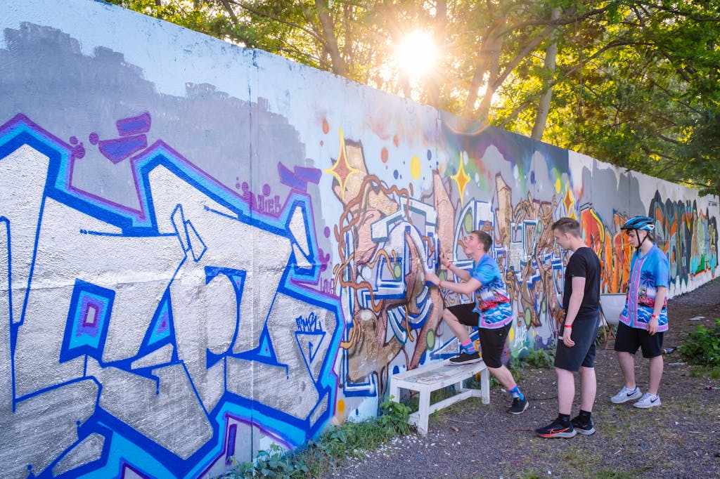 Jugendliche vor Graffiti an der Hinterlandmauer im Park am Nordbahnhof
