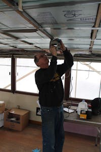 crew member performing off-season maintenance on boat