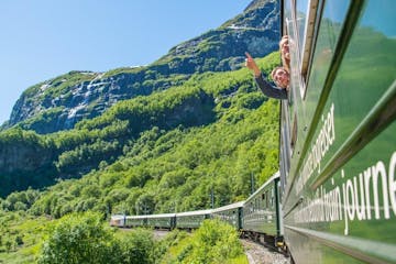 a green train that is on top of a mountain