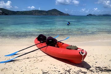 Seas the Day Charters USVI rented kayak on Sugar Bay Beach, St. Thomas USVI with two guests snorkeling in the water