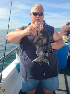 Jerry Kill holding a fish on a boat