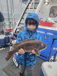 a young boy holding a fish