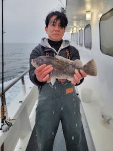 a person holding a fish on a boat in the water