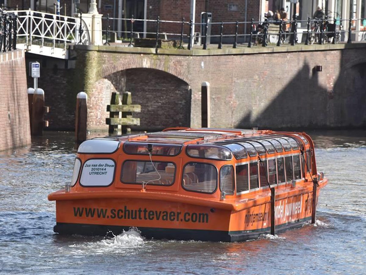 a bus is traveling down the water in front of a building