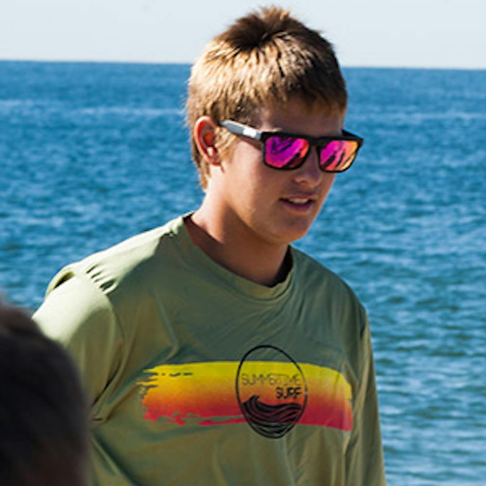 a person wearing sunglasses and a body of water