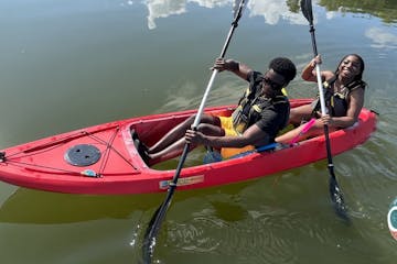 a man riding on the back of a boat in a body of water