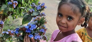 a little girl holding a flower