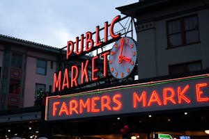 a large clock mounted to the side of Pike Place Market