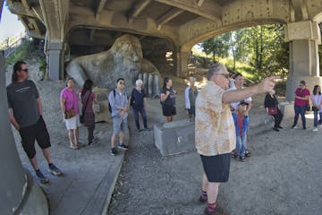 a group of people standing in front of the Fremont Troll on a Seattle Walking Tour