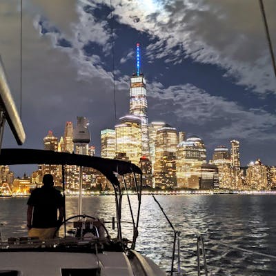 Private NYC Night Sailboat Tour with man looking at the Manhattan skyline