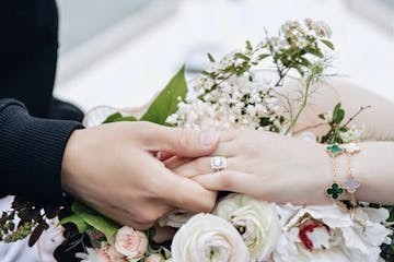 engagement ring and flowers and couple holding hands on a romantic boat
