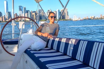 woman drinking champagne on a private sailboat with the Manhattan skyline in the background