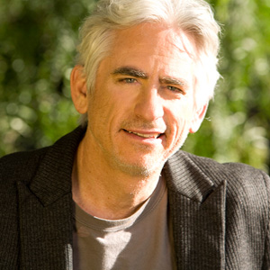 David Benoit wearing a suit and tie smiling and looking at the camera