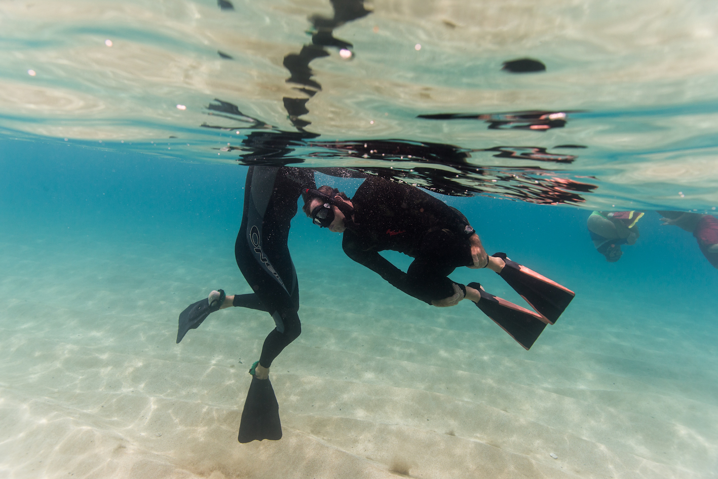 Two scuba divers practicing apnea and surf survival skills