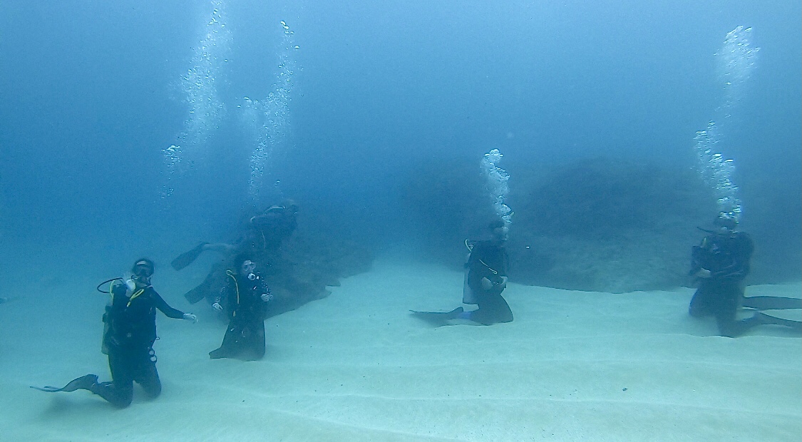 Newly trained PADI Rescue Divers await instruction underwater from the dive instructor.