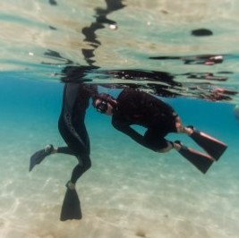 Two surfers underwater practicing apnea and surf survival skills at apnea course