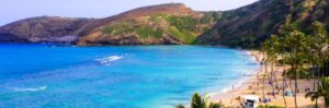 a view of a beach next to a body of water with Hanauma Bay in the background