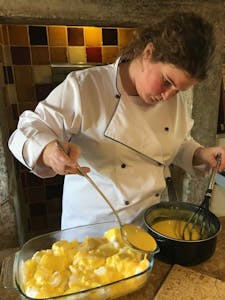 uma senhora a preparar uma sobremesa portuguese à base de ovos