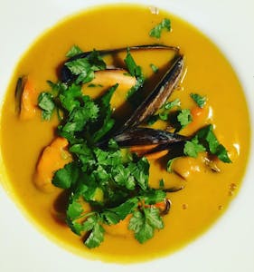 a bowl of pumpkin soup with mussels