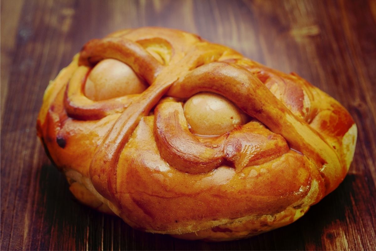 a close up of a piece of portuguese sweet bread on a wooden table