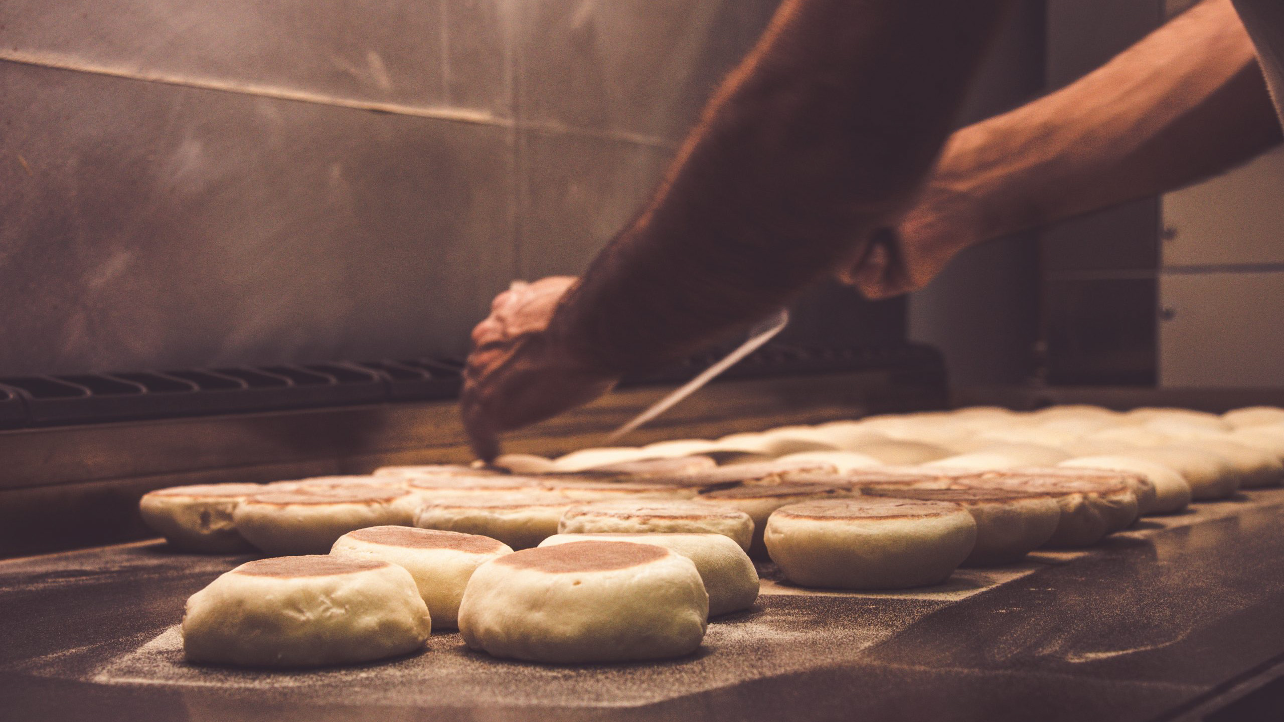 a man cooking hot dogs on a grill