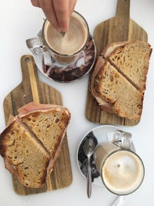 a piece of bread on a cutting board with a cake on a plate