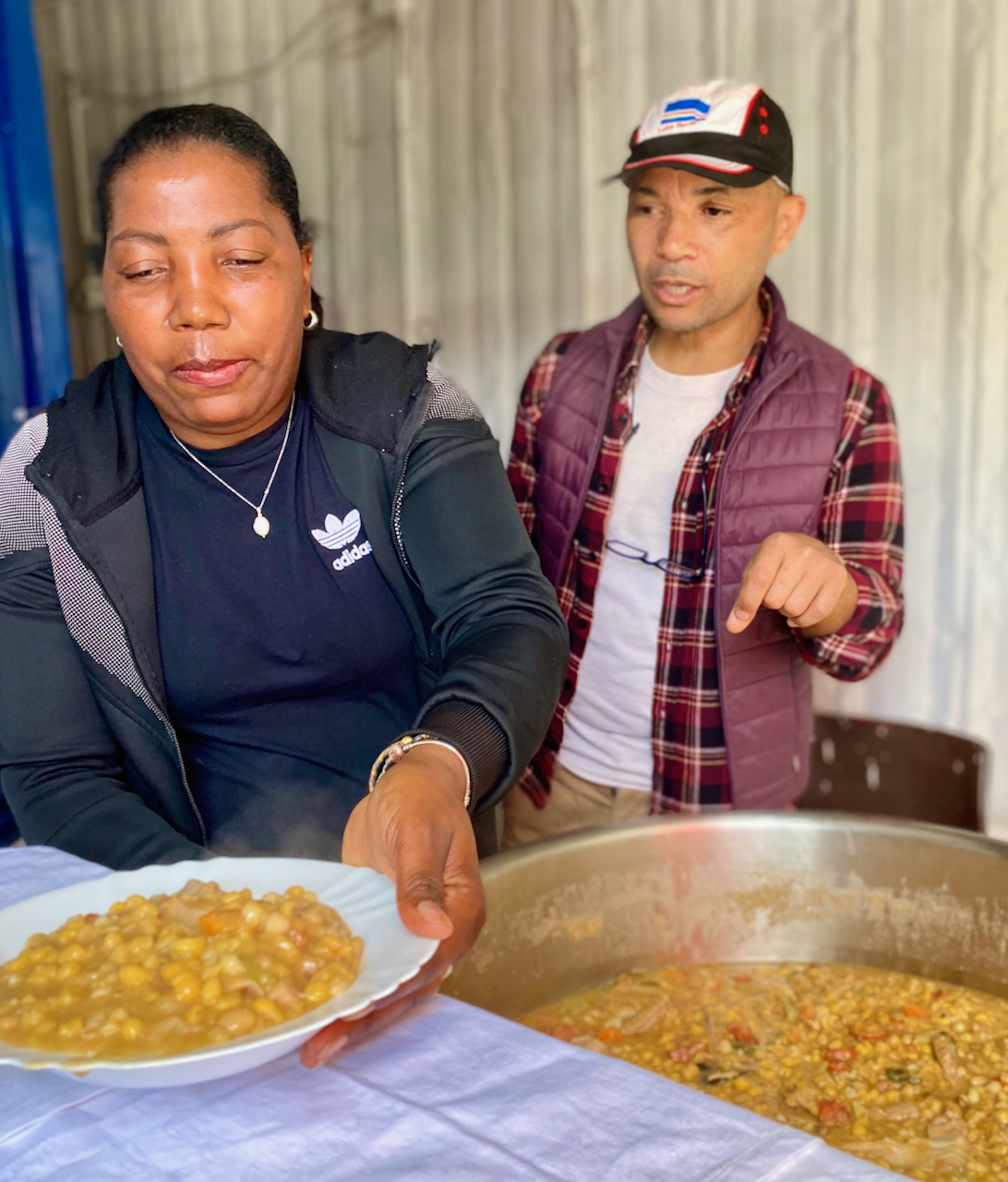 a group of people standing in front of a plate of food