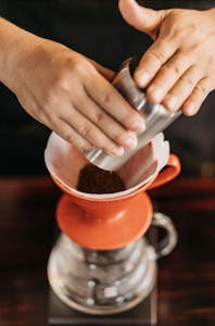 a close up of a person holding a cup and doing coffee