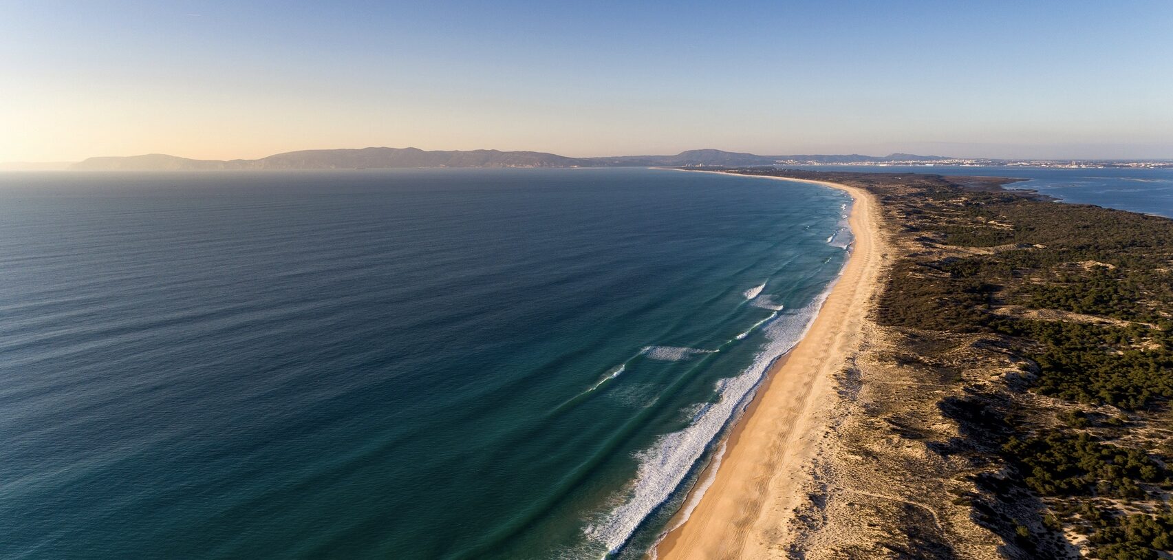 a sandy beach next to a body of water