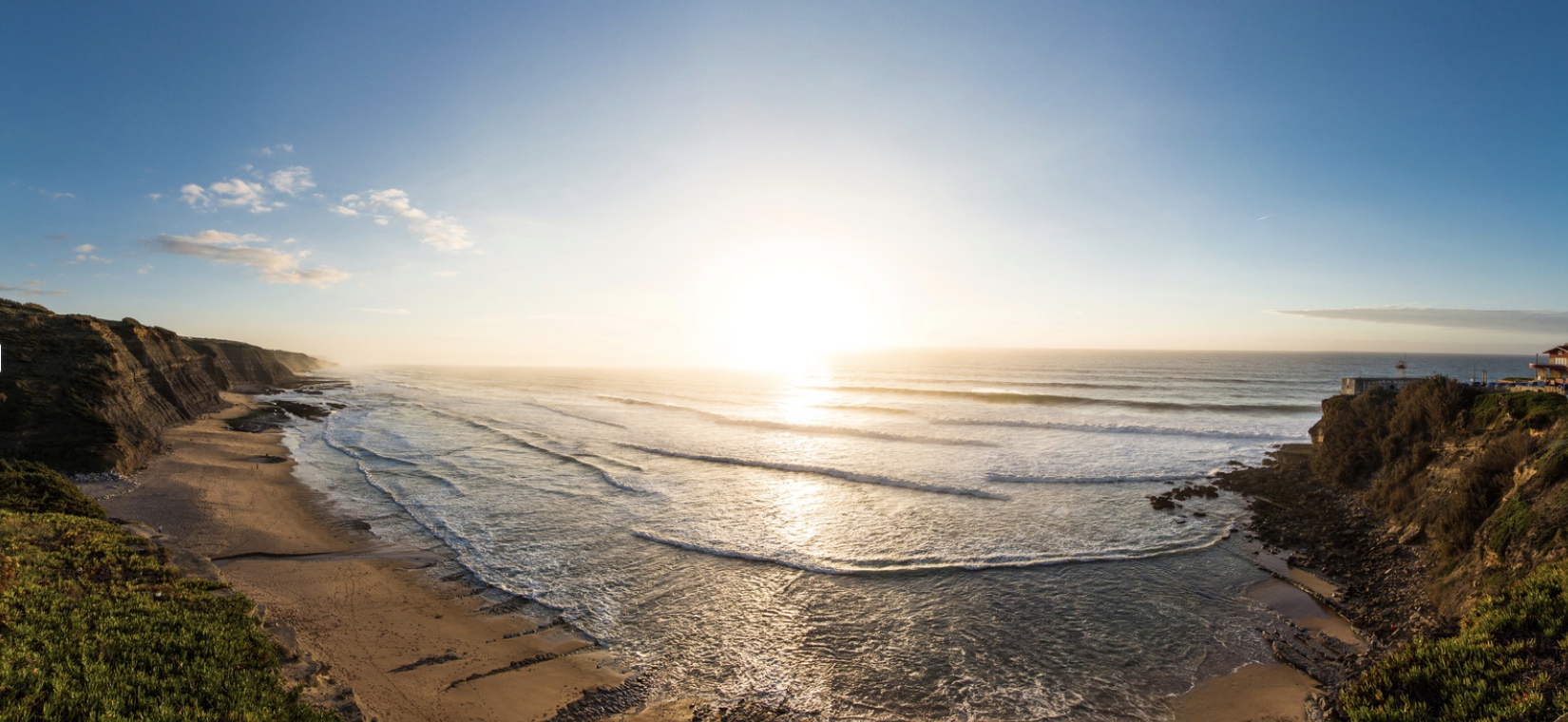 a sandy beach next to a body of water