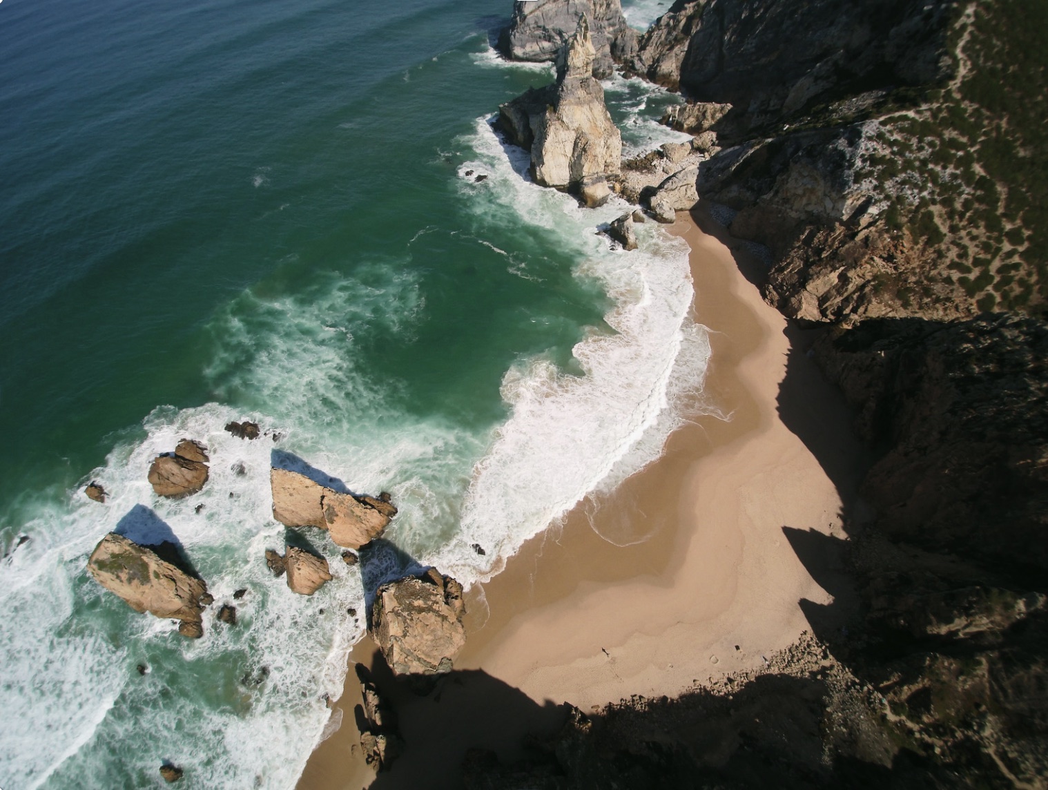 a person sitting on a rock near the ocean