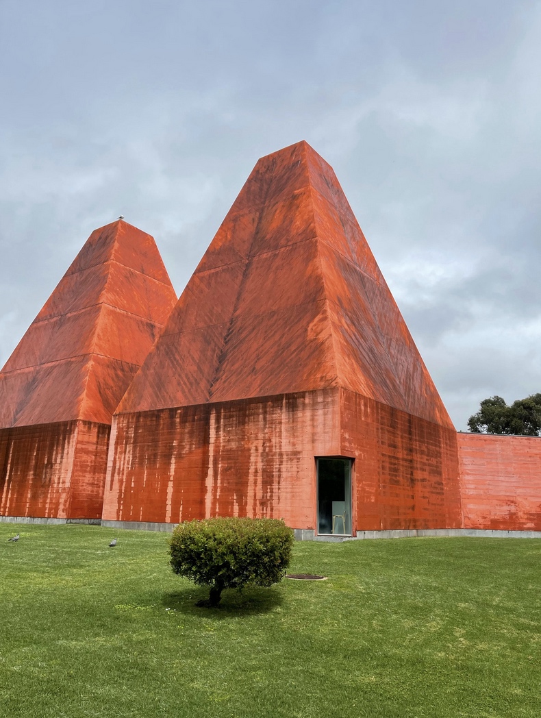 a large brick building with a mountain in the background