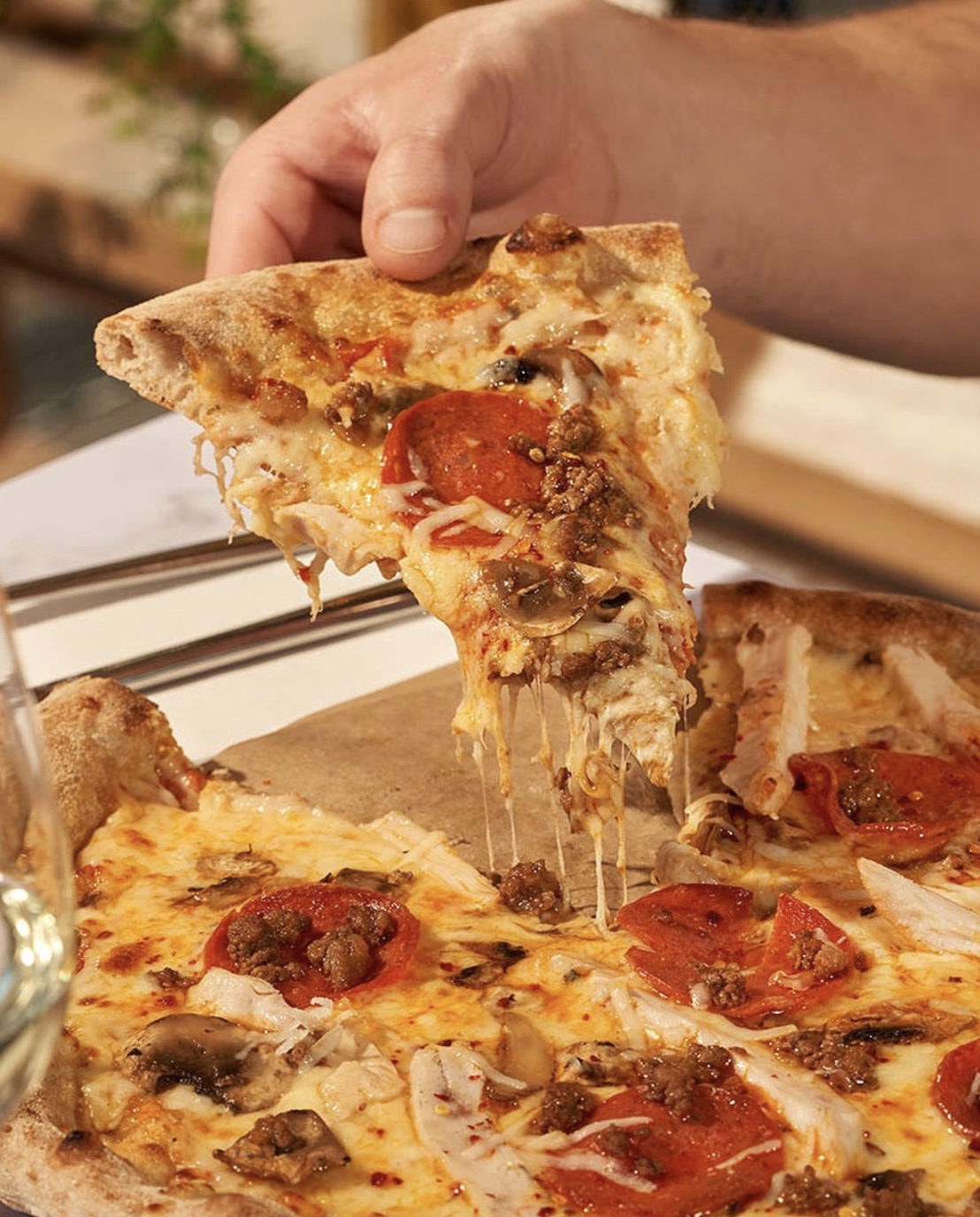 a close up of a person holding a slice of pizza