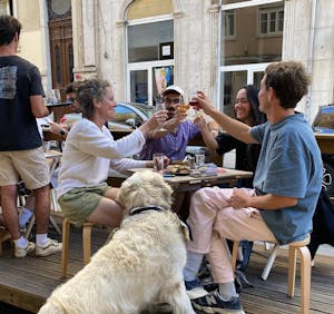 people seated at the table cheering outdoors in lisbon