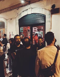 a group of people standing in front of a bar drinking